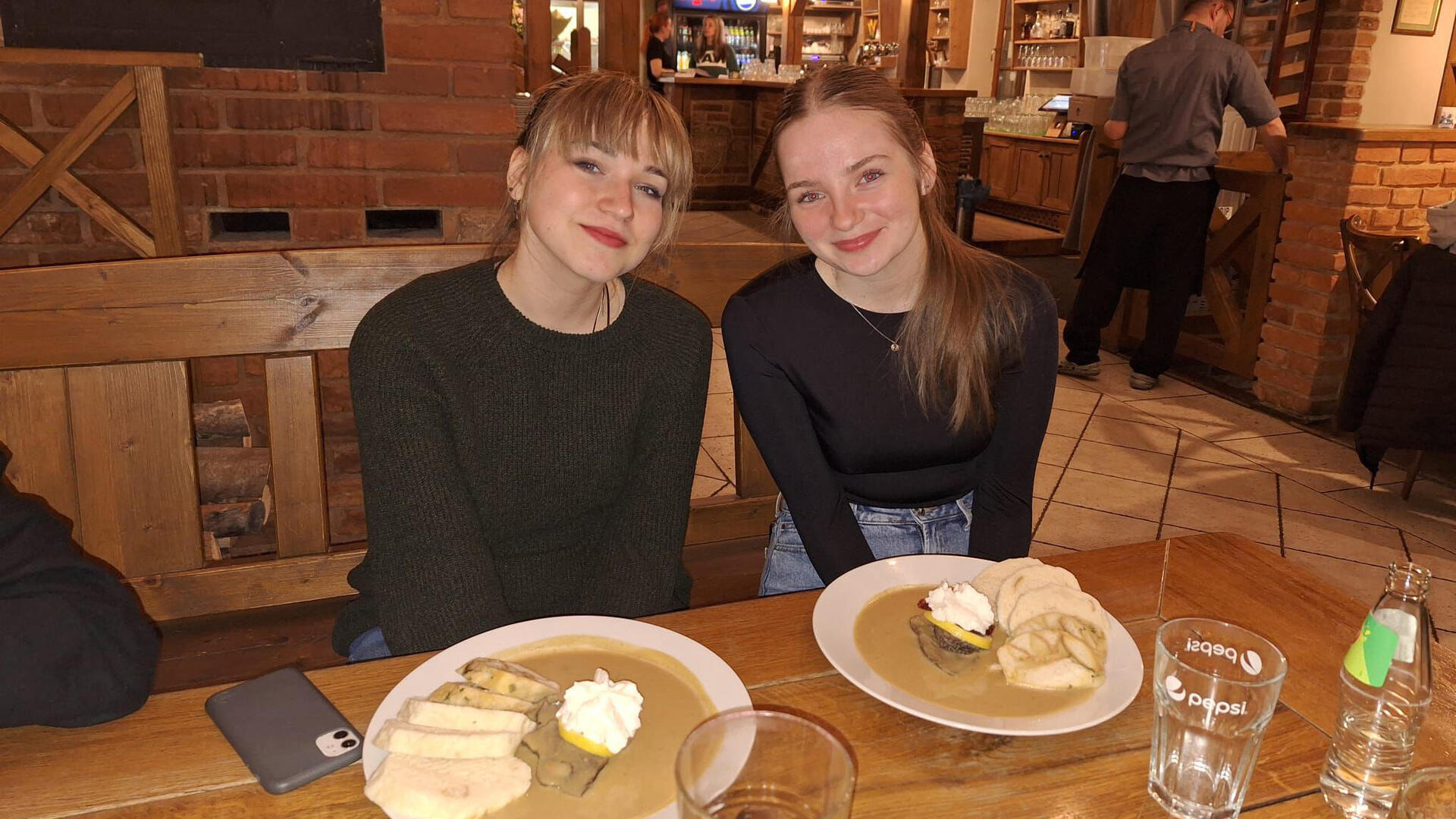 Laura sitzt mit ihrer Austauschpartnerin Eli in einem Restaurant in Pilsen und isst ein typisch tschechisches Gericht