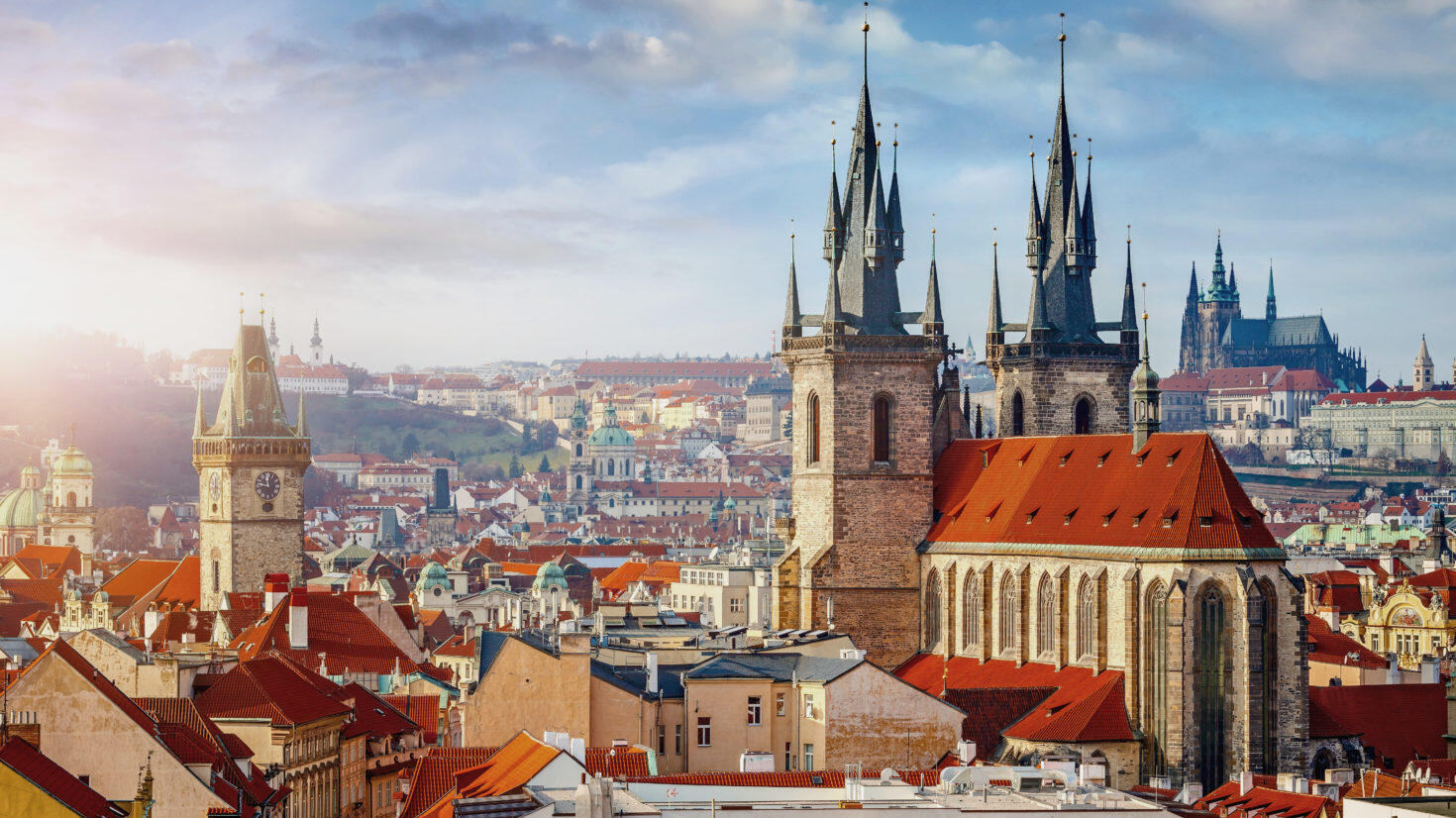 Panorama von Prag mit roten Daechern und hohen Tuermen bei Tag
