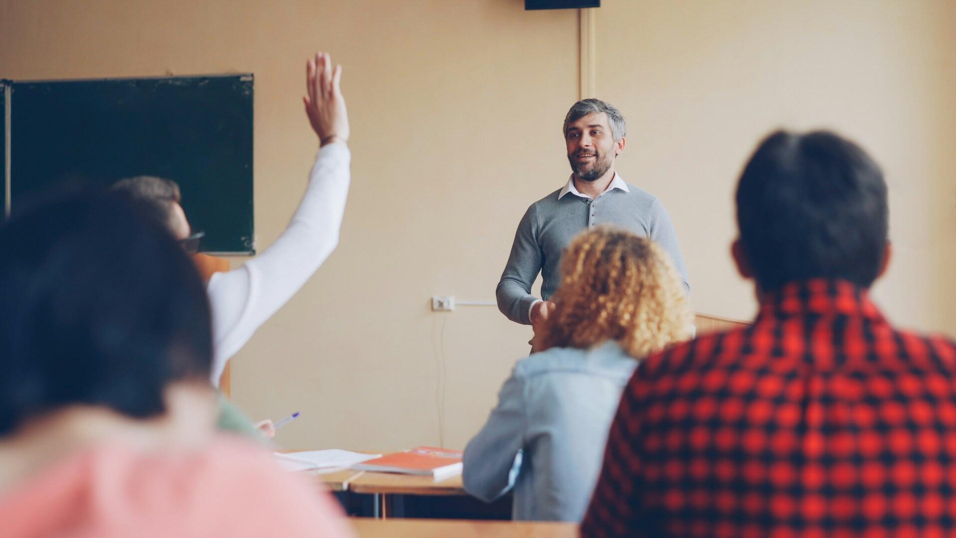 Lehrer, der den Schülern im Klassenzimmer eine Frage stellt.