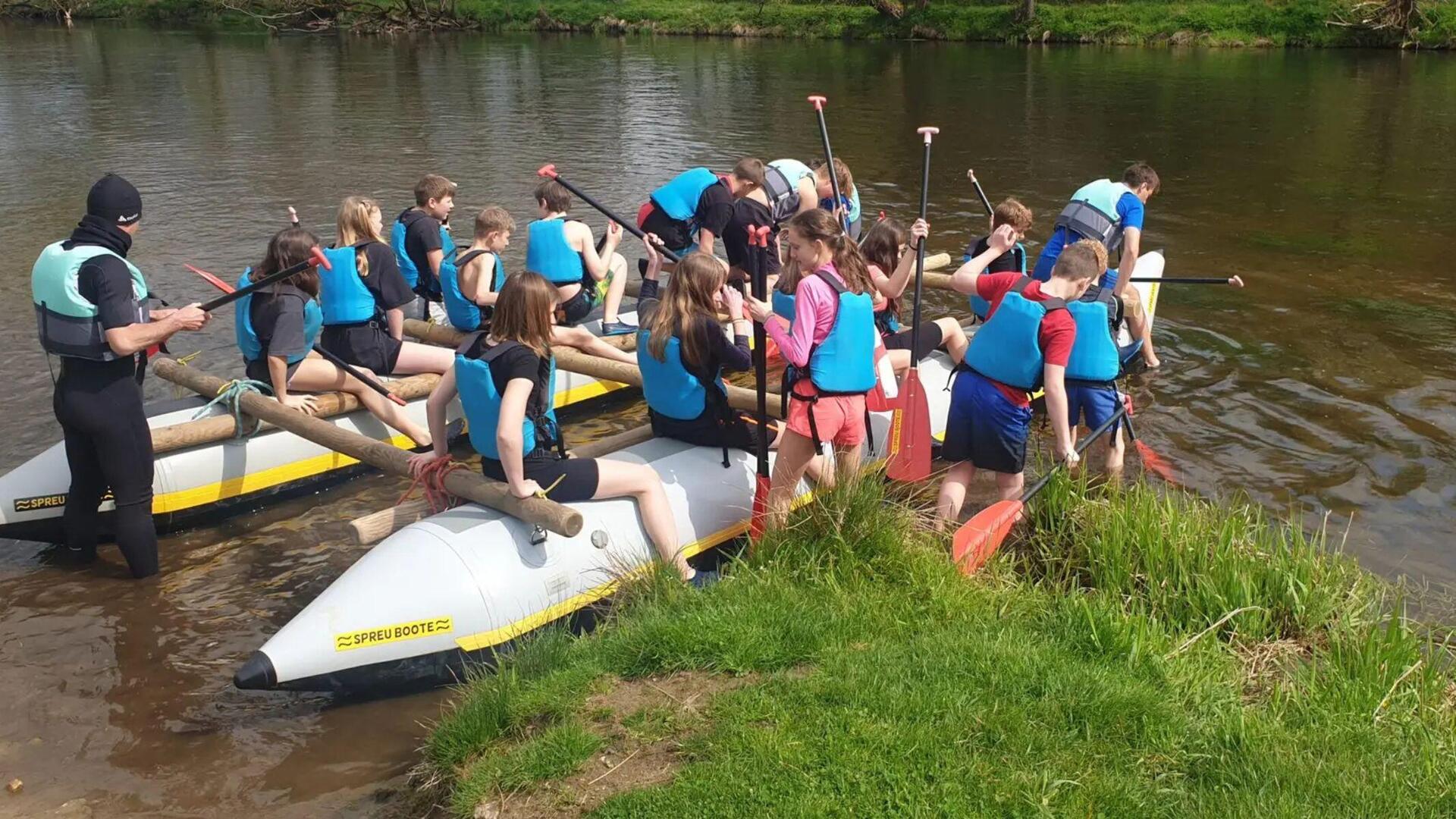 Jugendliche am Fluss mit Kanus