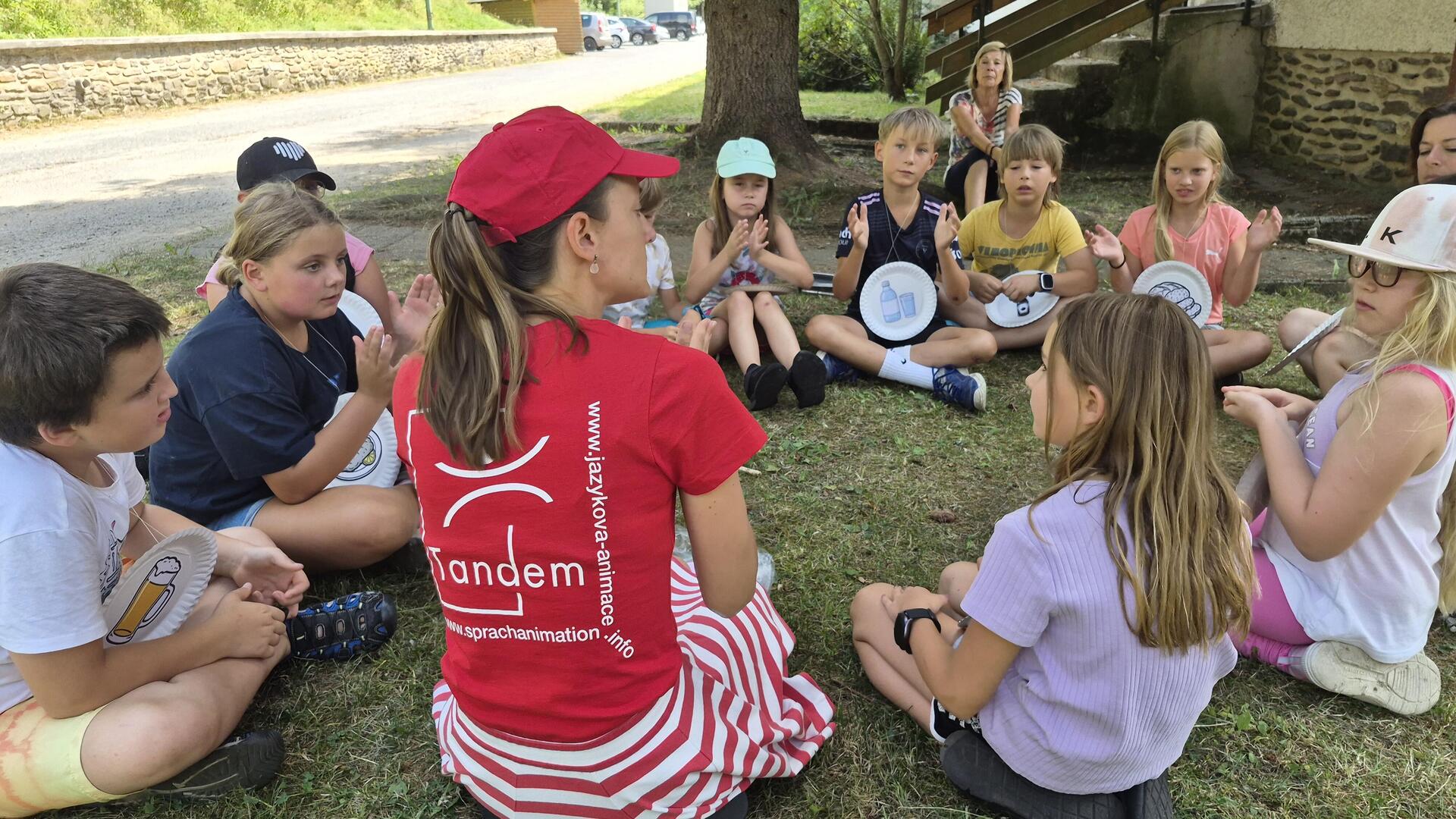 Eine Sprachanimateurin sitzt in einem Kreis mit Kindern